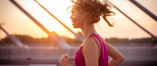 Female athlete running over the bridge in the morning