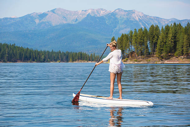 istock Beautiful woman paddleboarding on scenic mountain lake 511677520