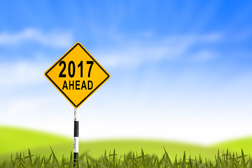2017, Road sign in the grass field to new year and blue sky, can use as abstract background