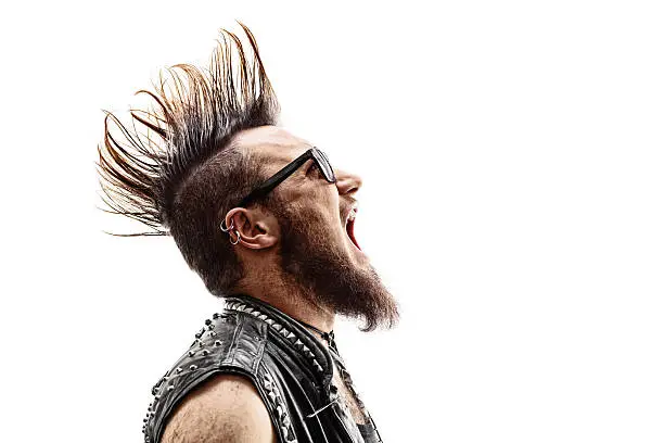 Profile shot of an angry young punk rocker with a Mohawk hairstyle screaming isolated on white background