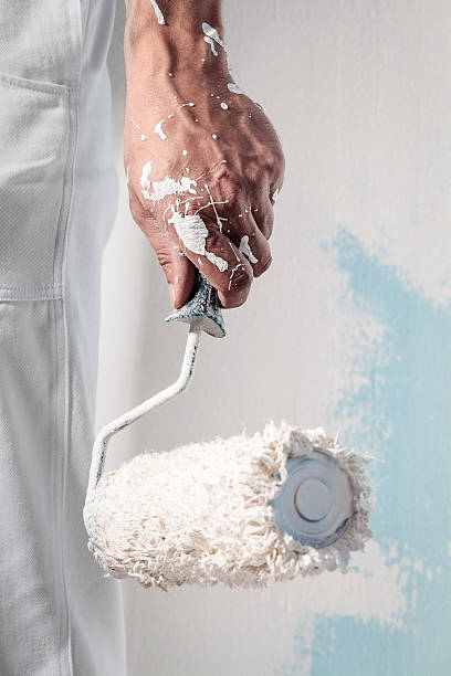 Workman Hand holding Dirty Paintroller Close up Of Professional Workman Hand holding Dirty Paintroller rough hands man stock pictures, royalty-free photos & images
