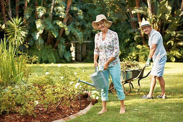 se trata de una tarea difícil pero nos encanta! - gardening senior adult action couple fotografías e imágenes de stock