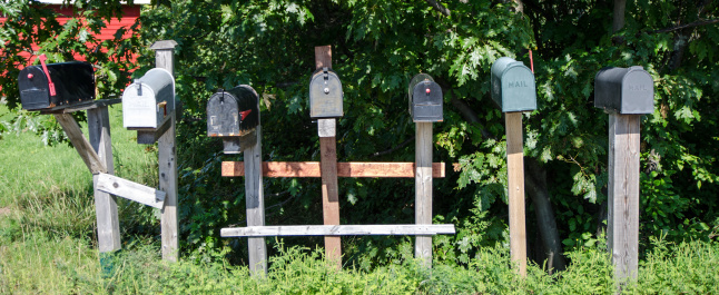 Rural mailboxes in line besides each other on the side of the road
