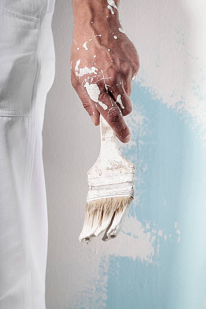 Workman Hand holding Dirty Paintbrush stock photo