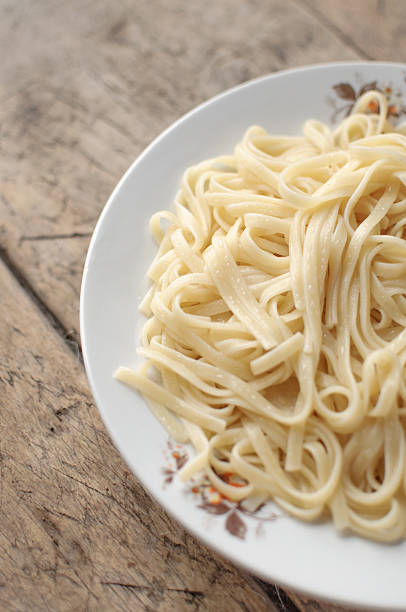 istock Spaghetti in a white bowl on a wooden surface 511718626