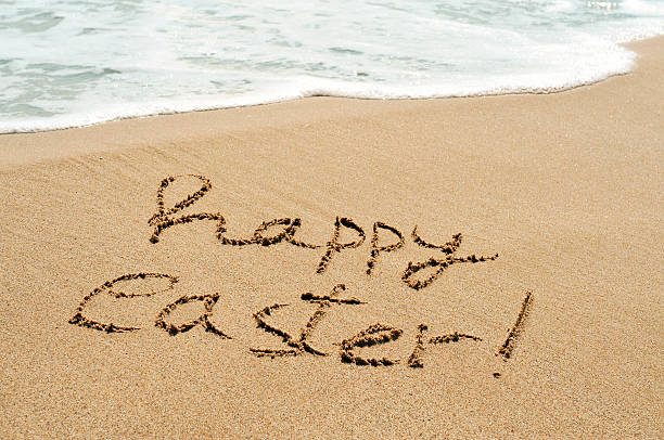 istock happy easter written in the sand of a beach 511719168