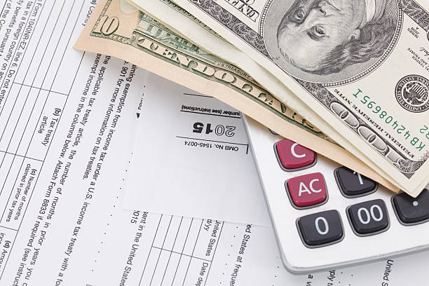 istock Money and calculator on tax form background 511719892