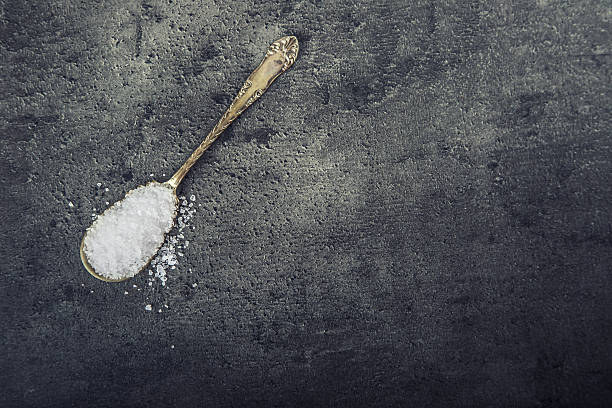 istock Salt. Coarse grained sea salt on granite background 511724348