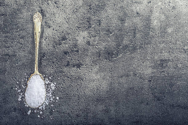 istock Salt. Coarse grained sea salt on granite background 511724508