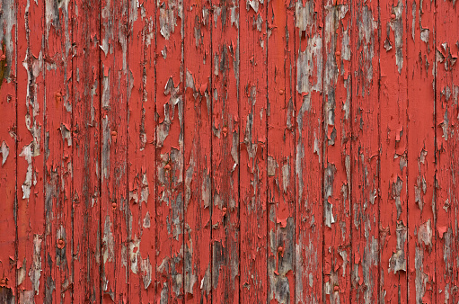 Weathered wooden boards with peeling red paint