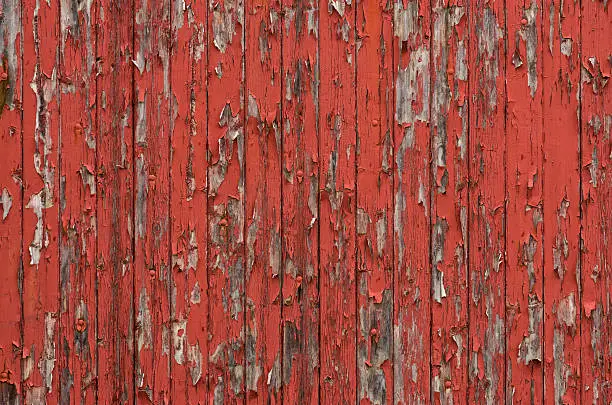 Photo of Weathered wooden boards with peeling red paint