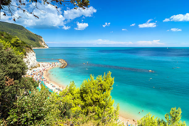 Sirolo beach in Conero national park, Italy day view of famous beach crowded with tourists in Sirolo, Italy. adriatic sea stock pictures, royalty-free photos & images