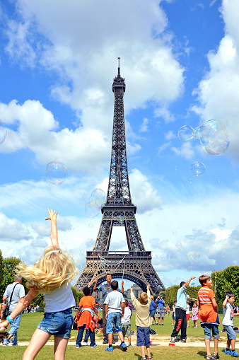 Paris, France - 19 August 2014 - Children play with soap bubbles near the Eiffel Tower on a beautiful August day