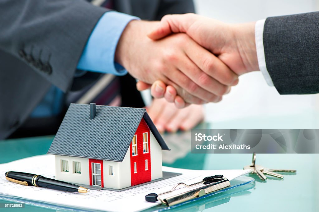 Handshakes with customer after contract signature Estate agent shaking hands with customer after contract signature House Stock Photo