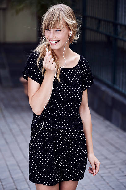 Beautiful woman in spotted dress with earphones