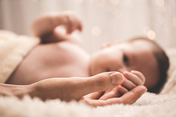 Newborn holding mother's finger