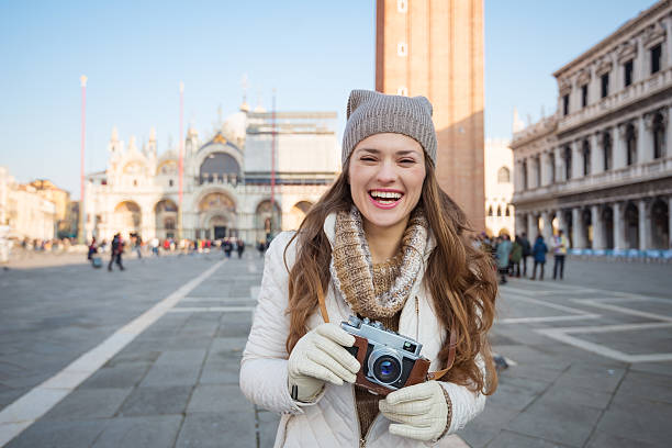 istock Smiling woman with retro photo camera on Piazza San Marco 511732292