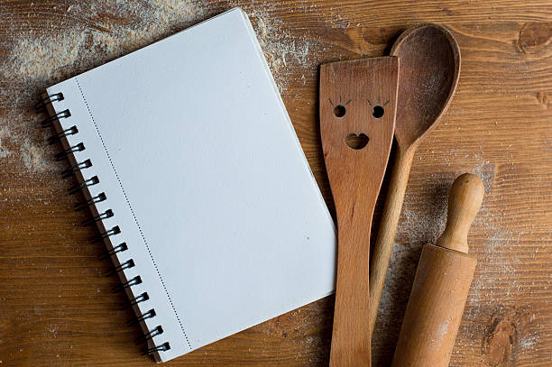 istock Open recipe book with wooden spoon, rolling pan and spatula 511732502