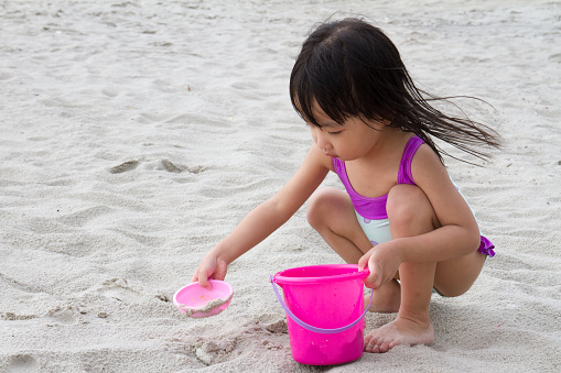 Asian Little Chinese Girl Playing Sand with Beach Toys on Tropical Beach
