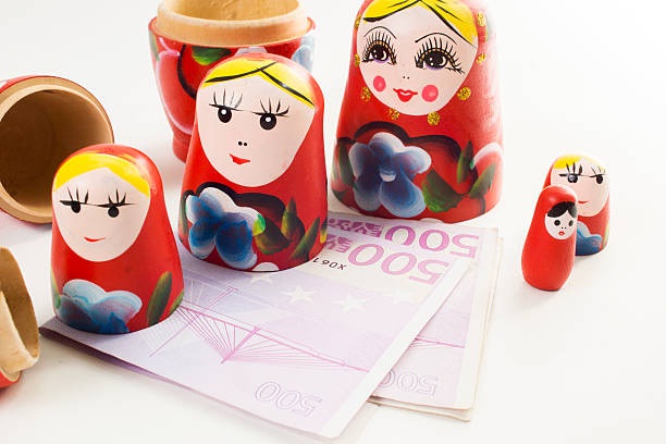 babuschka-kopftuch mit dem euro banknote - russian nesting doll gender symbol human gender russian culture stock-fotos und bilder