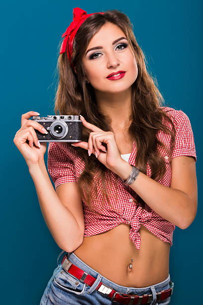istock Pretty brunette girl posing with retro camera on blue background 511736002