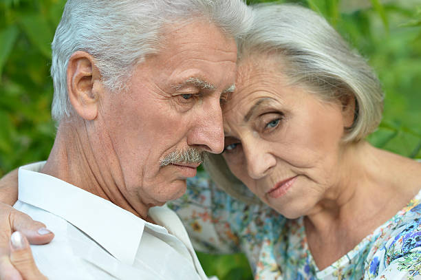 istock sad mature couple  in summer park 511736344