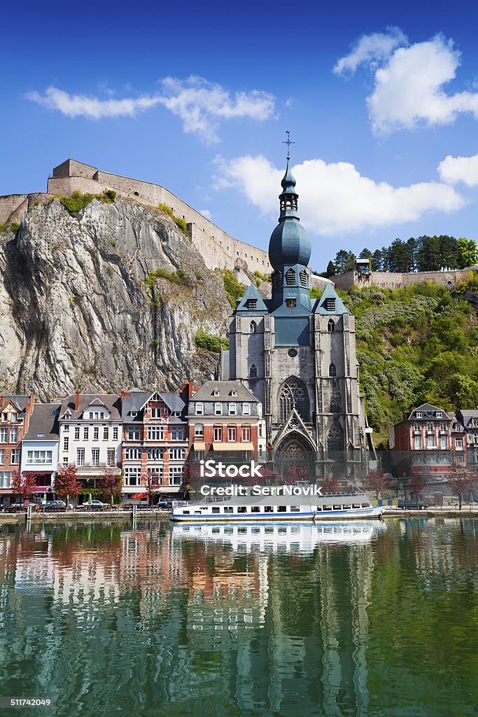 Dinant Collegiate Church on Meuse river Dinant Collegiate Church of Our Lady near Meuse river with white ship in Belgium Belgium Stock Photo