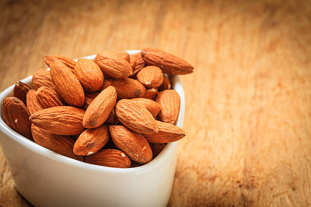 istock Almonds in bowl on wooden background 511742279