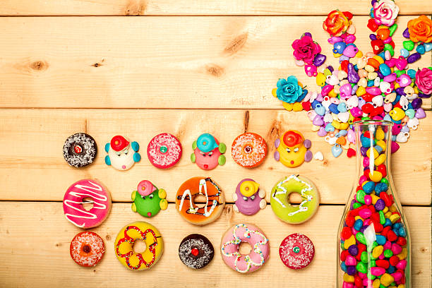 Sweet donuts pastel color with rose flower on wooden background