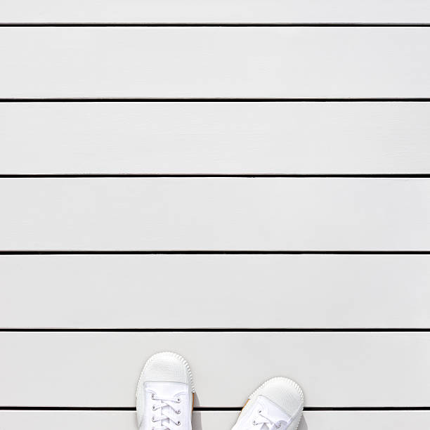 istock white sneakers on wooden floor 511742857