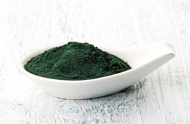 istock Spirulina powder in white porcelain spoon 511743066