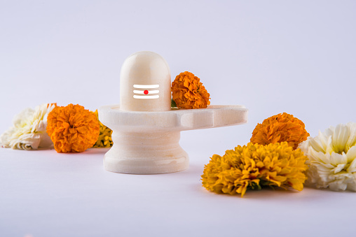 Shiva Linga made up of white marble decorated with flowers & bael leaf known as Aegle marmelos, maha shiva ratri a festival of hindu God shankar or shankar bhagwan or bholenath