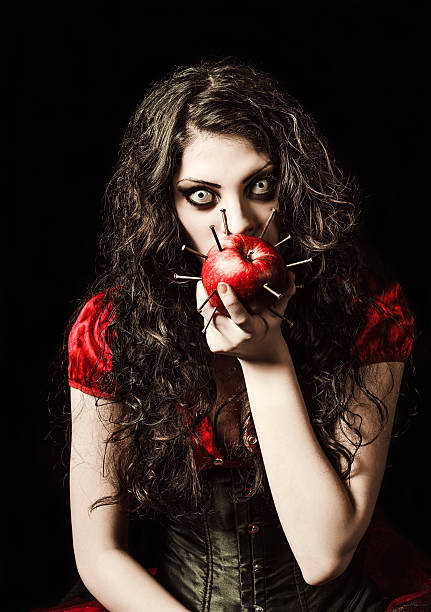 istock Horror shot: strange scary girl eats apple studded with nails 511744075