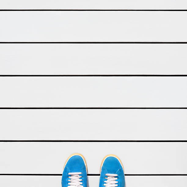 blue sneakers standing on wooden deck