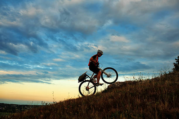 istock Silhouette of a biker and bicycle on sky background 511744152