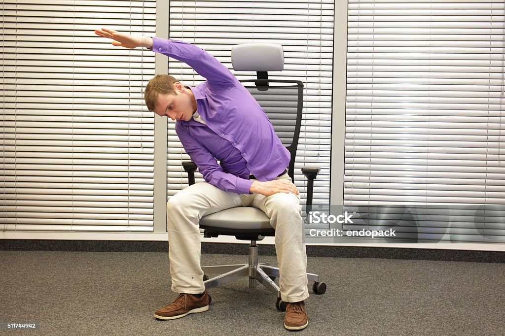 man exercising on chair in office, healthy lifestyle man exercising on chair in office, healthy lifestyle - front view Chair Stock Photo