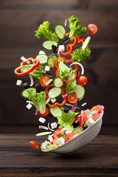 istock flying salad on wooden background 511745890