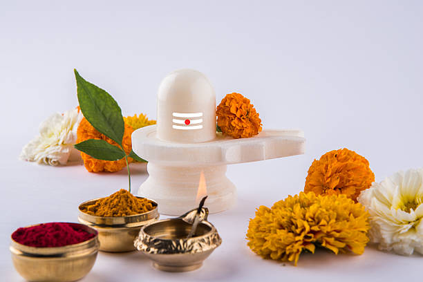 shiva linga aus weißem marmor mit blumen, mahashivaratri - shivalinga stock-fotos und bilder