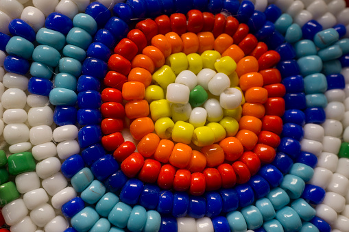 A macro photo of Native American style indian beads.  It has a circular star pattern and is very colorful.