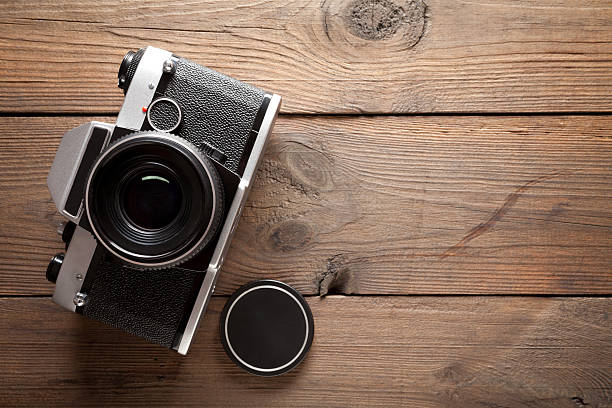 istock Vintage camera on old wooden table 511748188