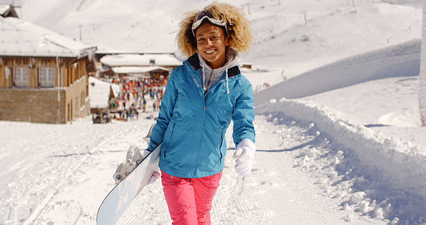 istock Smiling pretty young woman carrying a snowboard 511748988