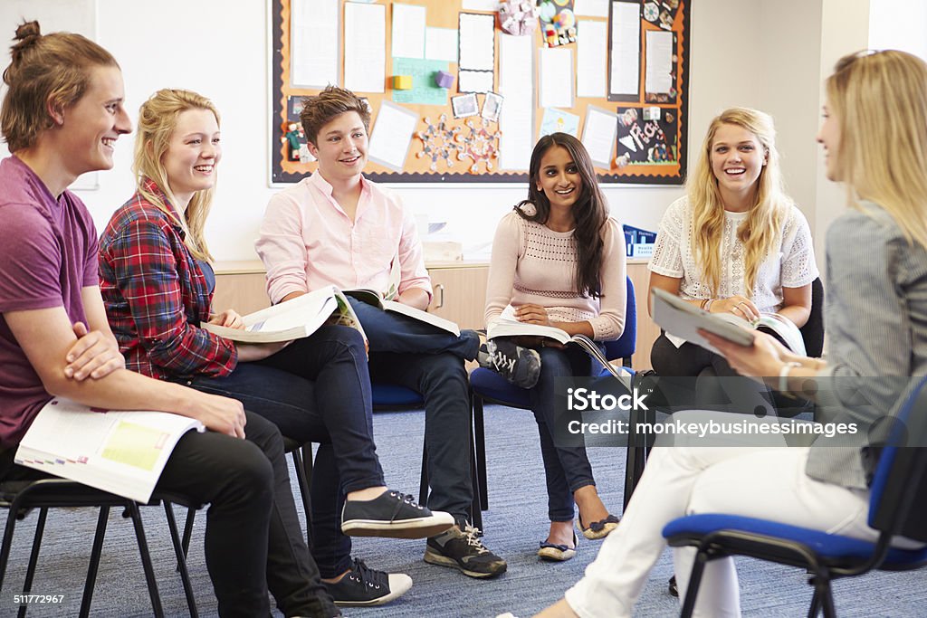 College Students With Tutor Having Discussion Instructor Stock Photo