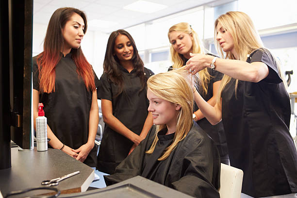 enseignant aidant les étudiants'entraînement pour devenir un coiffeur - coiffeur photos et images de collection