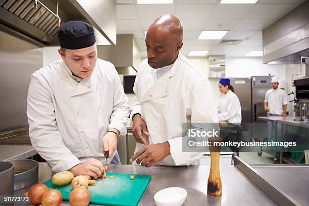 Teacher Helping Students Training To Work In Catering Stock Photo - Download Image Now