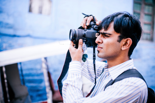 A man stands taking a photograph, Jodhpur, Rajasthan, India. 