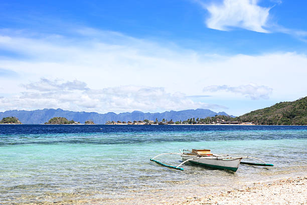 istock Outrigger fishing boat stranded at exotic beach 511775439