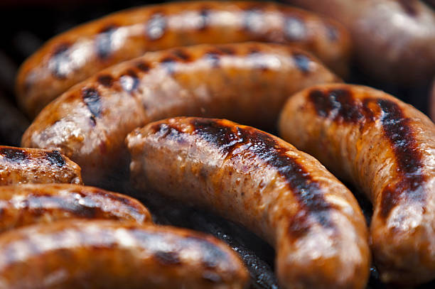Italian Sausages Cooking on a Grill A group of Italian Sausages cook on a grill. sausage stock pictures, royalty-free photos & images