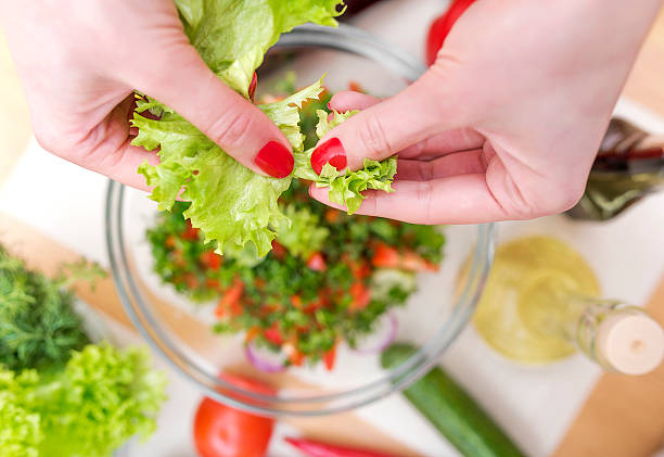 Female hand tearing lettuce