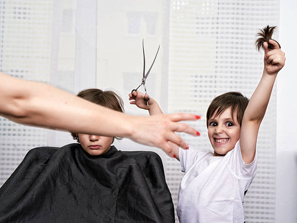 hairdresser gone mad! evil little boy with funny face feeling glad for cutting hair to his brother.crazy expressions. angry hairstylist stock pictures, royalty-free photos & images
