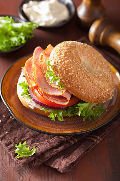 istock ham sandwich on bagel with cream cheese tomato onion 511788450